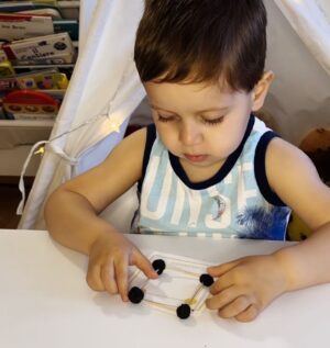Michele haciendo una actividad con formas de palitos y masa