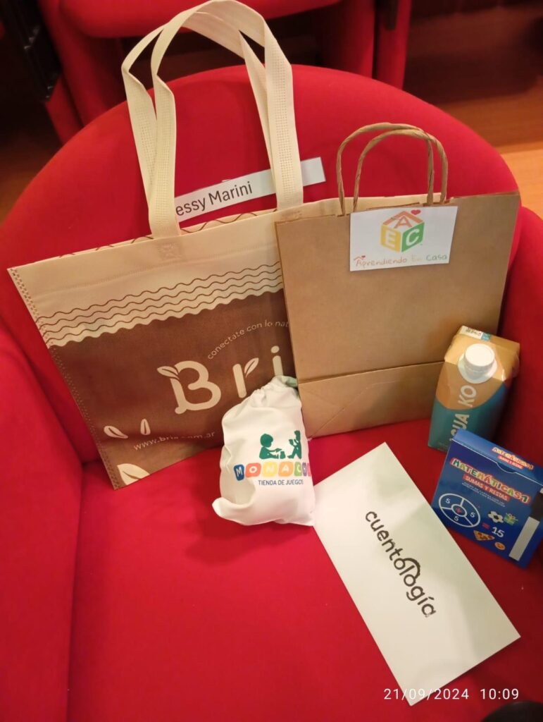 Detalle de dos bolsas, un juguete, un brick y juguetes en una butaca de teatro