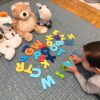 Michele formando palabras con letras juntos a sus peluches