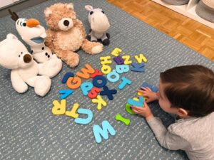 Michele formando palabras con letras juntos a sus peluches
